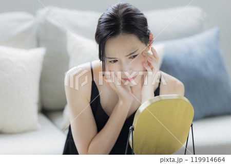 リビングでスキンケアをする女性　 119914664