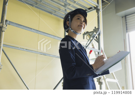 現場で図面を見るスーツの女性 現場で図面を見るスーツの女性 119914808