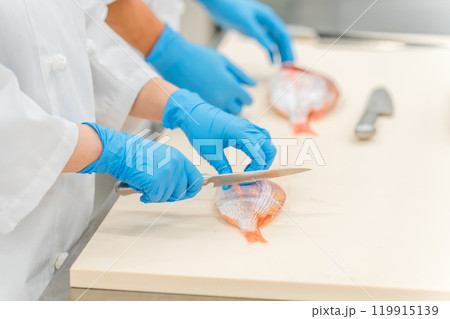 水産加工・鮮魚を捌く作業者・調理スタッフの手元（スーパー・バックヤード・調理師・食品加工・鮮魚市場） 119915139