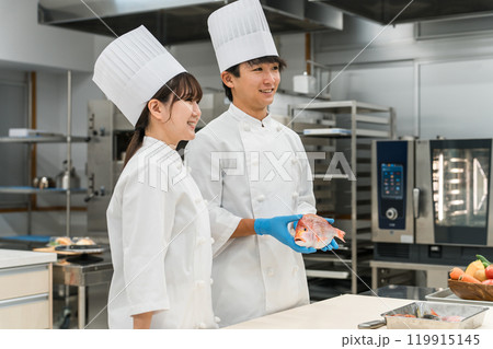 魚を調理するコックコート姿の男女スタッフ（料理人・生鮮市場・食品加工） 119915145
