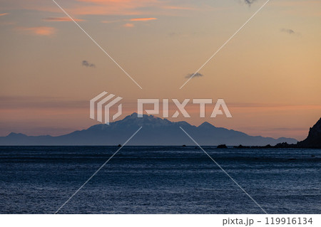 ニュージーランド ウェリントンのレッド・ロックスのビーチから見える南島と夕焼け空 ニュージーランド ウェリントンのレッド・ロックスのビーチから見える南島と夕焼け空 119916134