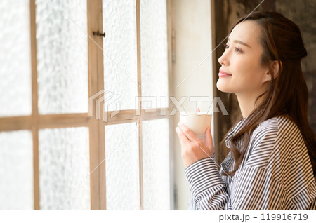 窓際でコーヒーを飲む女性 119916719