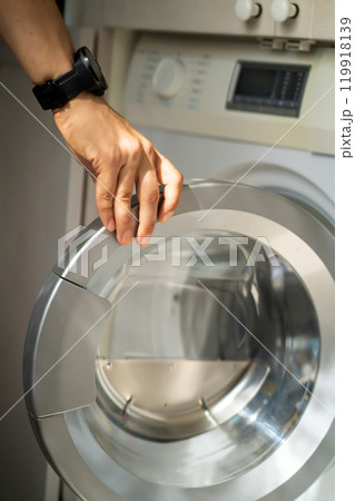 Man is using the modern washing mashine. Man is using the modern washing mashine. 119918139