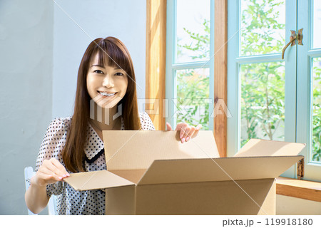 段ボール箱を開ける女性 段ボール箱を開ける女性 119918180