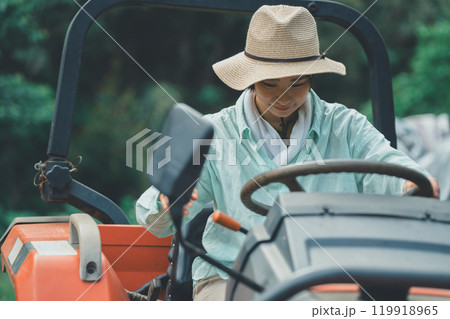 トラクターの運転をする女性 119918965