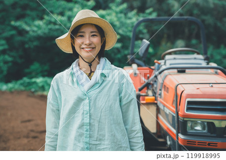 トラクターと笑顔の若い女性 トラクターと笑顔の若い女性 119918995