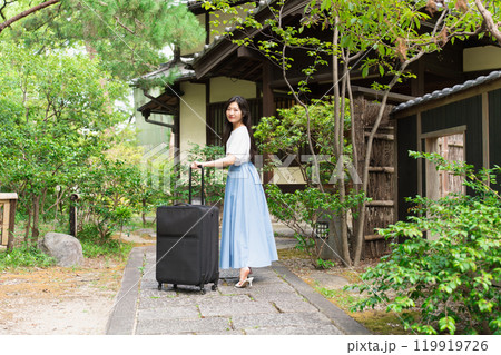 キャリーケースを引いて田舎に帰省する若い女性 旅行イメージ キャリーケースを引いて田舎に帰省する若い女性 旅行イメージ 119919726