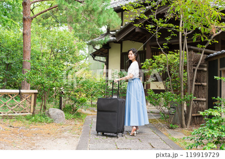キャリーケースを引いて田舎に帰省する若い女性 旅行イメージ キャリーケースを引いて田舎に帰省する若い女性 旅行イメージ 119919729