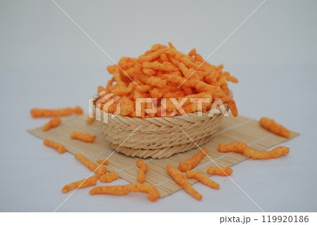 Crispy Corn Puffs in a wooden basket on bamboo mat. Selective focus Crispy Corn Puffs in a wooden basket on bamboo mat. Selective focus 119920186