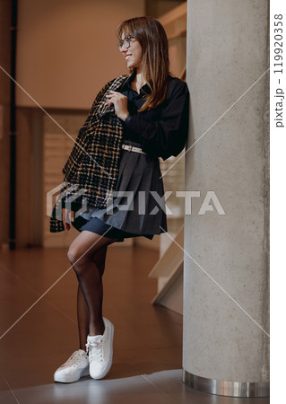 A Trendy Young Woman Posing Stylishly in Urban Fashion with Attitude and Confidence 119920358