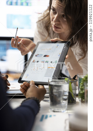 Business team looking into infographics and analytics to solve problems within the project progress, preparing solutions to ensure performance and efficiency. Eliminate challenges in meeting. Business team looking into infographics and analytics to solve problems within the project progress, preparing solutions to ensure performance and efficiency. Eliminate challenges in meeting. 119921122