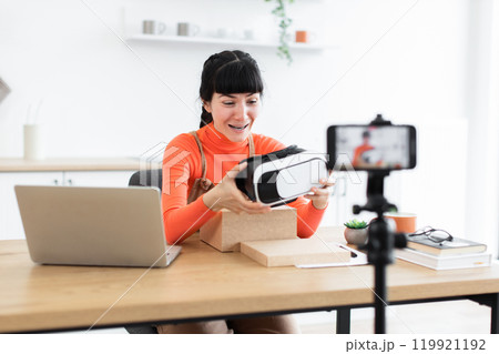 Caucasian female blogger unboxing new virtual reality headset 119921192