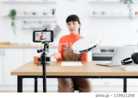 Caucasian female blogger reviewing latest robot vacuum cleaner online 119921208