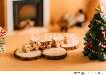 クリスマスの木製ミニチュアトレインと暖炉のある温かなシーン クリスマスの木製ミニチュアトレインと暖炉のある温かなシーン 119921802