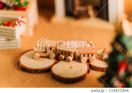 クリスマスの木製ミニチュアトレインと暖炉のある温かなシーン 119921804