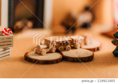 クリスマスの木製ミニチュアトレインと暖炉のある温かなシーン クリスマスの木製ミニチュアトレインと暖炉のある温かなシーン 119921805