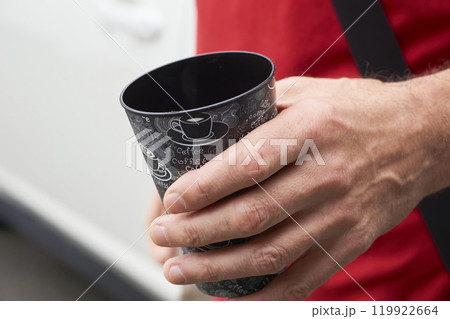 Coffee break. Man driver with a cup of coffee near the car 119922664