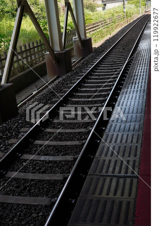 駅のホームから長く続く電車の線路 119922677