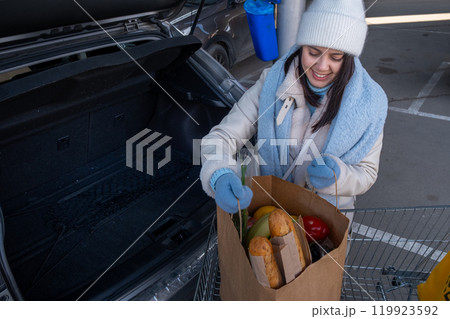 Woman uploading Groceries into Car 119923592