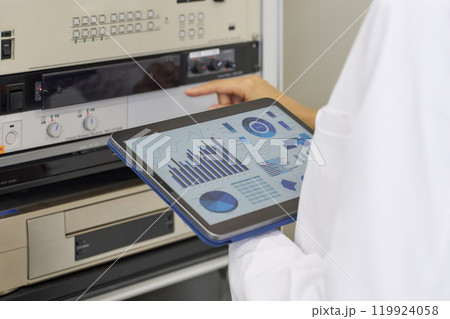タブレットを持って電子機器を操作するエンジニア 119924058