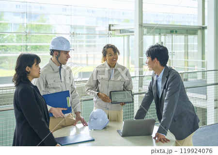 ビル内で会議する多国籍エンジニアとビジネスパーソンのグループ 119924076
