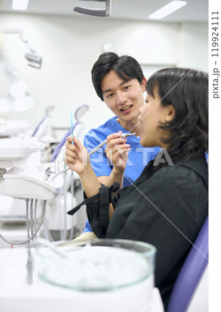 歯の治療をする歯科医 119924111