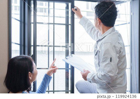 窓のサッシの点検をする修理業者と客 119924136