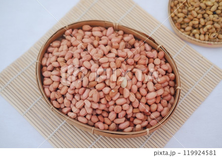 Peanuts in a basket on a bamboo mat, top view. Peanuts in a basket on a bamboo mat, top view. 119924581