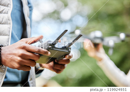 Close up of male hands holding drone controller and pushing buttons while enjoying tech assisted videography outdoors copy space 119924931