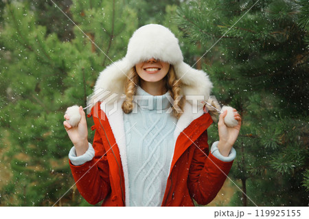 Winter portrait of happy smiling woman having fun enjoys snow against Christmas tree in forest 119925155