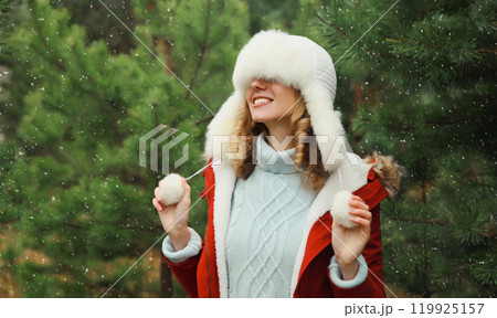 Winter portrait of happy smiling woman having fun enjoys snow against Christmas tree in forest 119925157