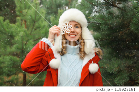 Winter portrait of happy smiling woman with snowflakes having fun enjoys snow against Christmas tree 119925161