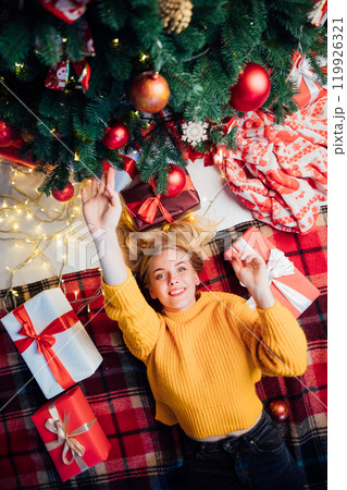 blonde woman with gifts at Christmas tree for new year blonde woman with gifts at Christmas tree for new year 119926321