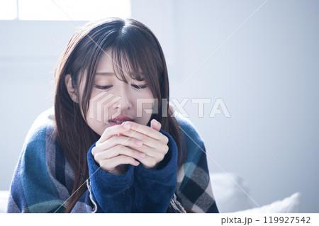 冬のパジャマを着た風邪で具合が悪すぎて頭痛が酷い女性のクローズアップ 寒気がして発熱がする～ 119927542