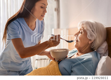 老人に食事を食べさせる人 119928011