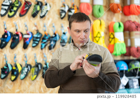 Man examine climbing shoes in store Man examine climbing shoes in store 119928485