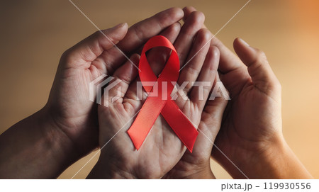 Hands holding red ribbon showing support for aids awareness 119930556