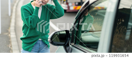車のトラブルで電話する女性　自動車事故で困る女性 119931654