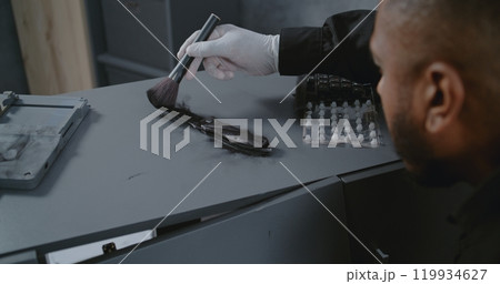 Close up of African American policeman or forensic scientist searching for fingerprints Close up of African American policeman or forensic scientist searching for fingerprints 119934627
