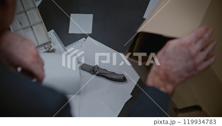 Top view on detective examining evidence at crime scene, finding knife Top view on detective examining evidence at crime scene, finding knife 119934783