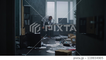 Aggressive businessman in fit of rage yells and destroys office room 119934905