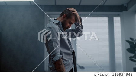 Stressed businessman stands, breathes heavily after destroying office room 119934942