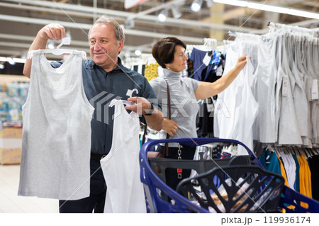 Elderly man and elderly woman choose t-shirt 119936174