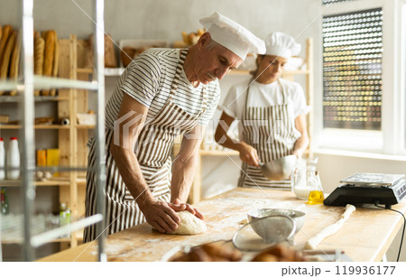 Elderly man and woman kneading and whipping dough Elderly man and woman kneading and whipping dough 119936177