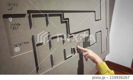 A boy reading the evacuation plan on the wall in braille. Close-up of a child reading braille. The concept of inclusiveness. World Sight Day. World Braille Day 119936267