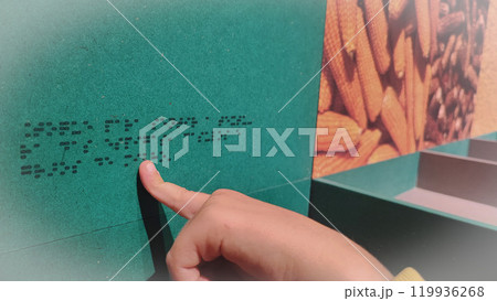 A boy reading the evacuation plan on the wall in braille. Close-up of a child reading braille. The concept of inclusiveness. World Sight Day. World Braille Day 119936268