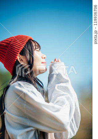 青空のもと遠くを見つめる若い女性 青空のもと遠くを見つめる若い女性 119936706