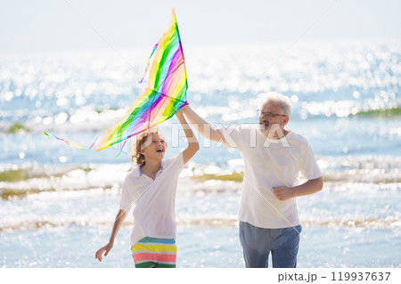 Grandfather and kids play on summer beach 119937637