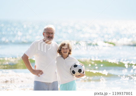 Grandfather and kids play football on beach. Grandfather and kids play football on beach. 119937801