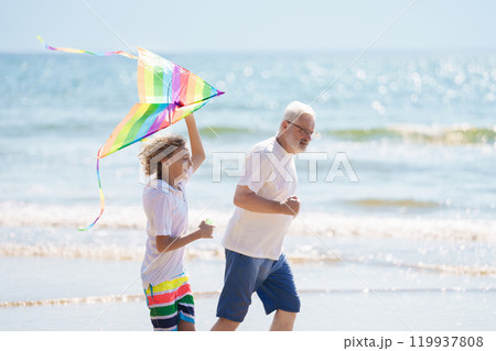 Grandfather and kids play on summer beach Grandfather and kids play on summer beach 119937808